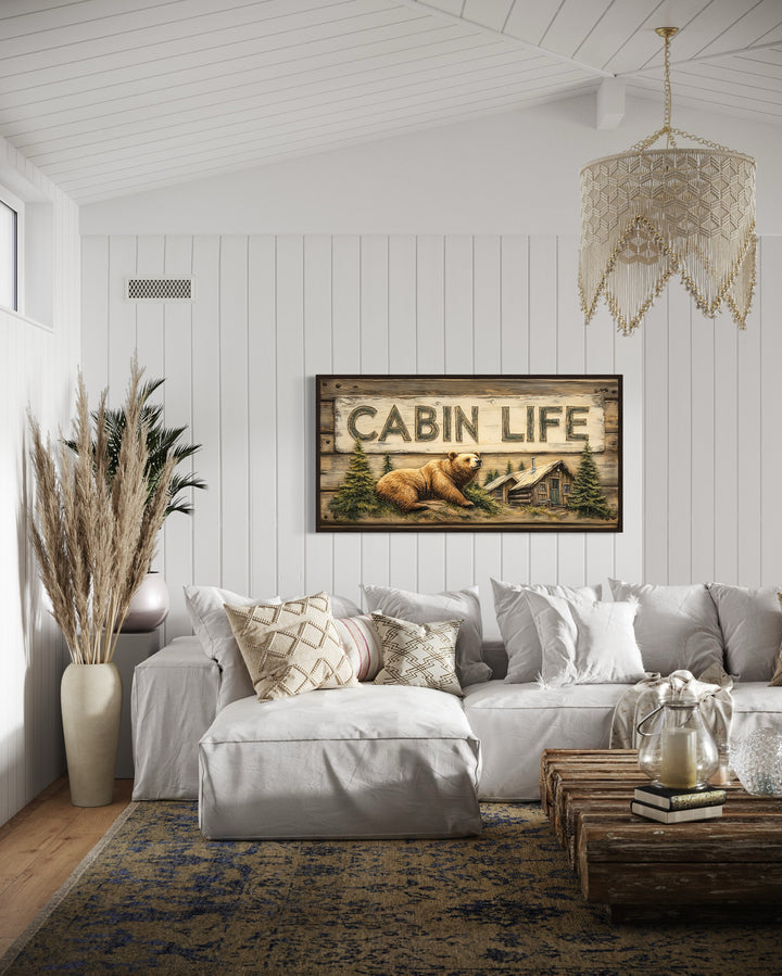 Cabin Life Sign With Log House And Bear Framed Canvas Wall Art in a living room filled with furniture and a painting on the wall