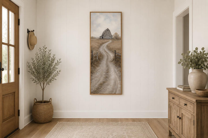 Tall narrow farmhouse wall art of a weathered barn and winding dirt road through golden fields.