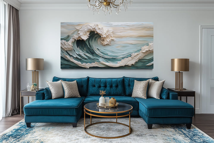 Abstract 3D effect teal ocean wave framed canvas wall art hanging above a blue sectional sofa.