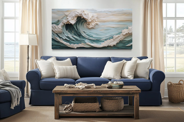 Abstract 3D effect teal ocean wave framed canvas wall art hanging above a blue sofa.