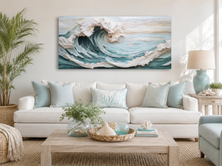 Abstract 3D effect teal ocean wave framed canvas wall art hanging above a white sofa.