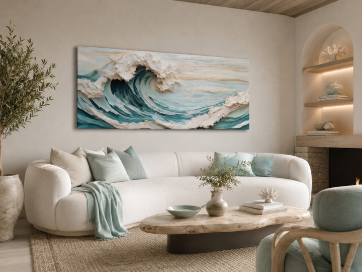 Abstract 3D effect teal ocean wave framed canvas wall art above a white sofa in a coastal room.