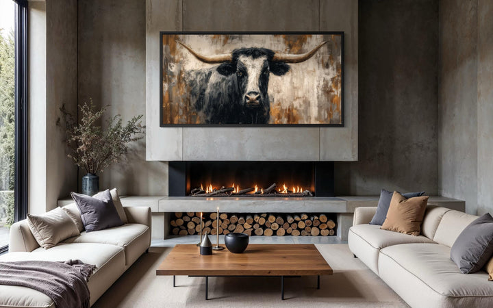 Abstract longhorn bull canvas wall art above a fireplace in a modern industrial living room.