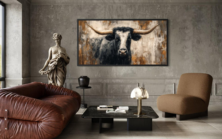 Abstract longhorn bull canvas wall art in a modern industrial living room with a brown sofa.