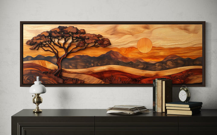 Acacia tree wall art in a wood carving style on a long narrow canvas over a dark wood sideboard.