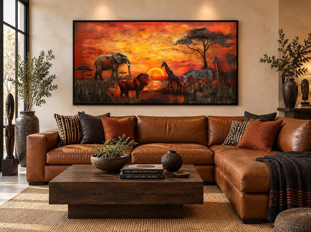 African Animals In Savannah At Sunset Framed Canvas Wall Art above a brown leather sofa.