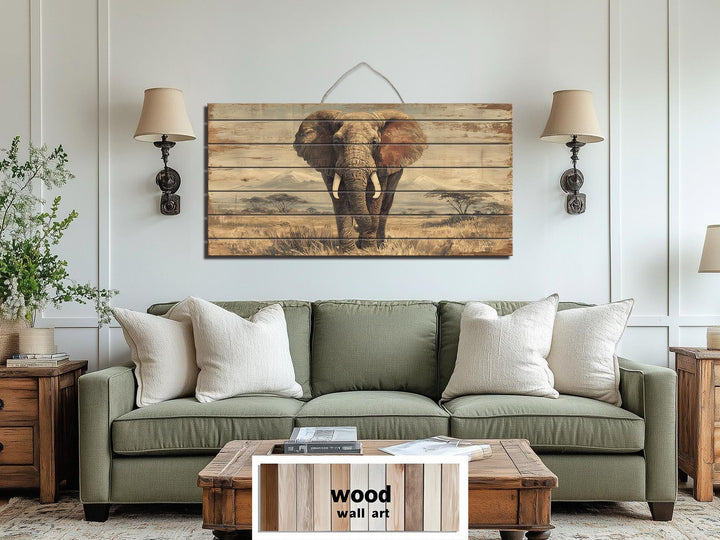 African elephant wall art on distressed wood planks hanging above a green sofa in a rustic room.
