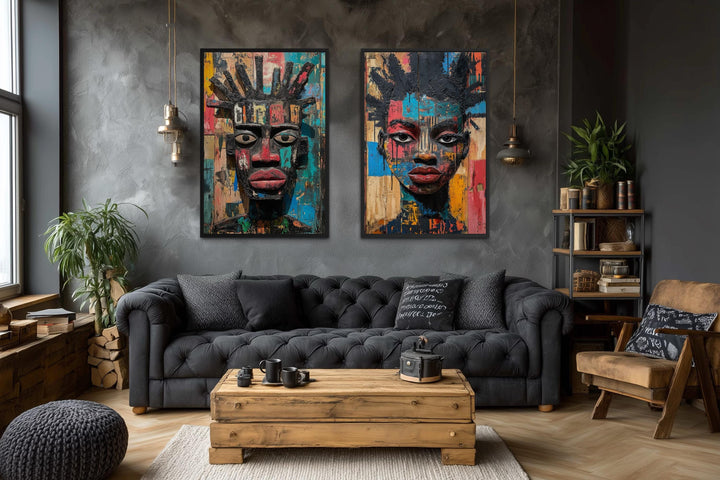 Set of two colorful African mask canvas prints featuring abstract tribal faces on a dark gray wall.