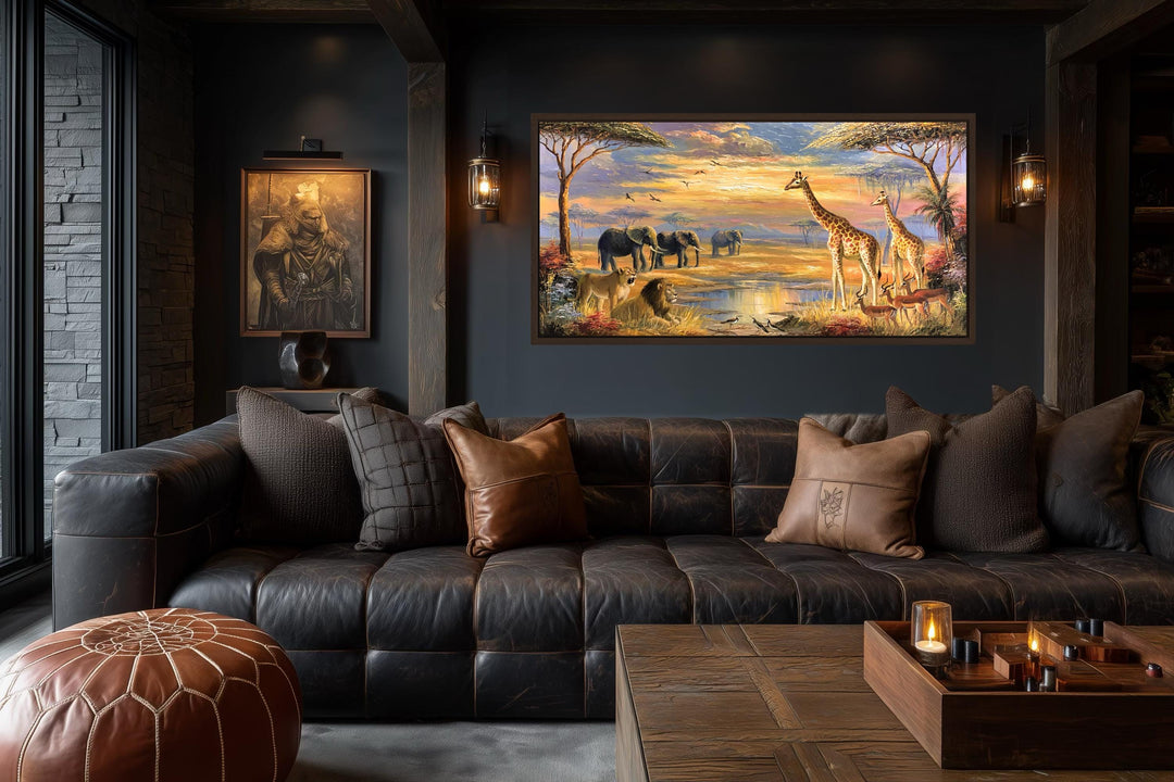 A panoramic canvas painting of African wildlife on a savanna at sunset hangs in a dark, moody room.