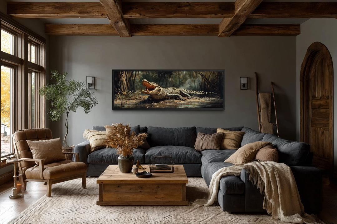 A long horizontal canvas print of an alligator in a swamp hangs in a rustic, modern living room.
