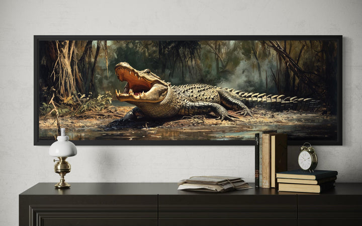 Horizontal canvas print of an alligator in a swamp, framed and displayed above a dark wood dresser.