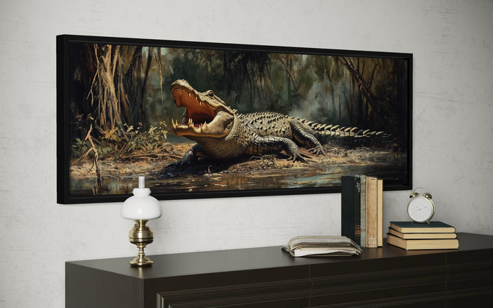 Horizontal canvas print of an alligator in a swamp, framed and hung above a dark wood dresser.
