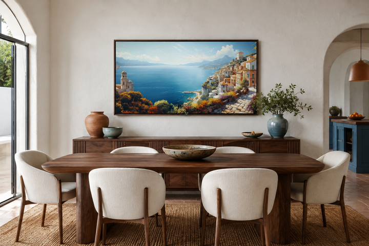 Framed Amalfi Coast wall art painting hanging above a wooden sideboard in a modern dining room.
