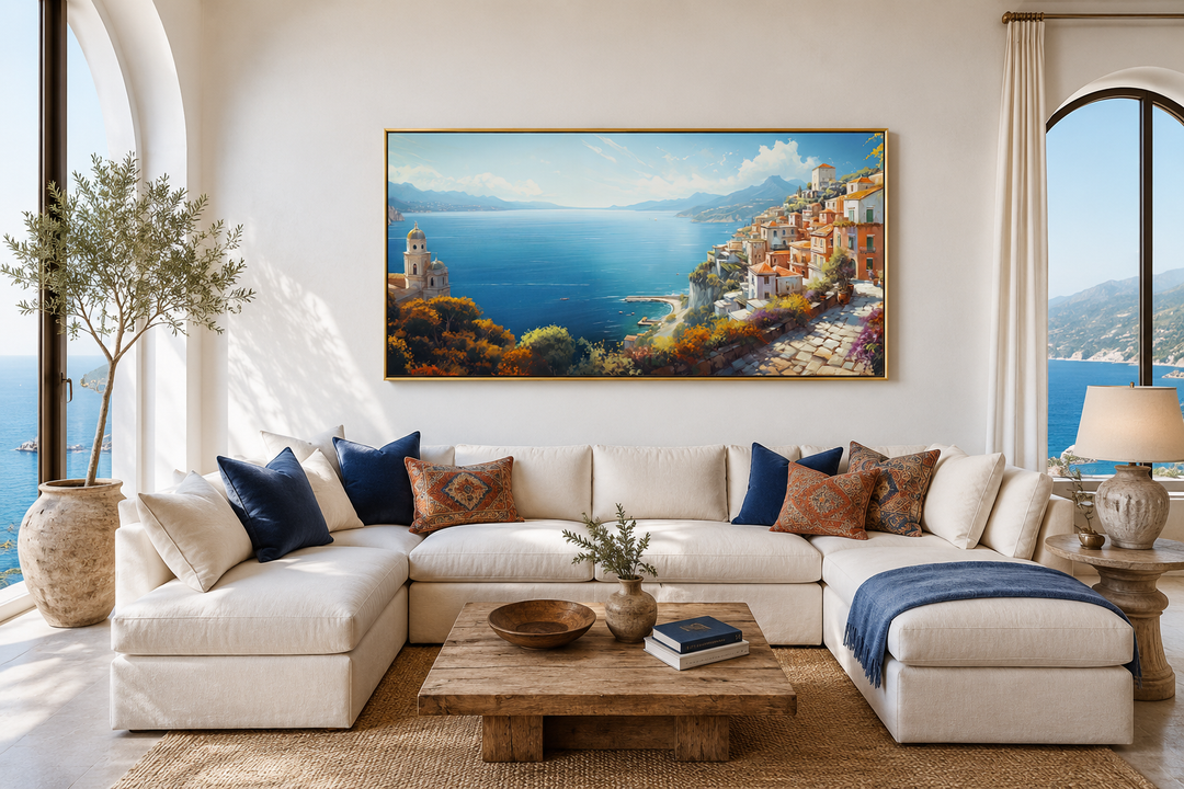 Large framed canvas print of the Amalfi Coast hanging above a white sectional sofa in a living room.