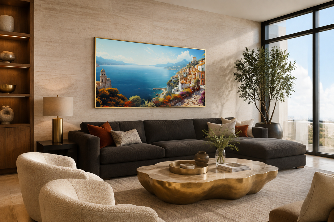 Large framed canvas print of the Amalfi Coast hanging above a dark sofa in a modern living room.