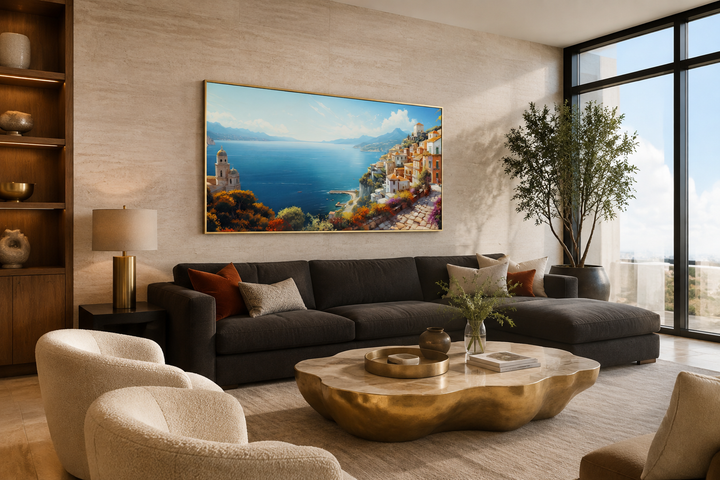 Large framed canvas print of the Amalfi Coast hanging above a dark sofa in a modern living room.