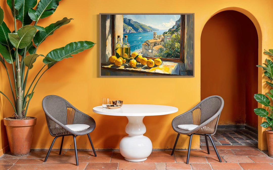 Amalfi Coast window view canvas art with lemons and olive oil above a white dining table.