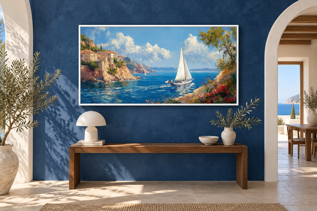 Amalfi Coast With Sail Boat Framed Canvas Wall Art displayed on a blue wall above a wooden bench.