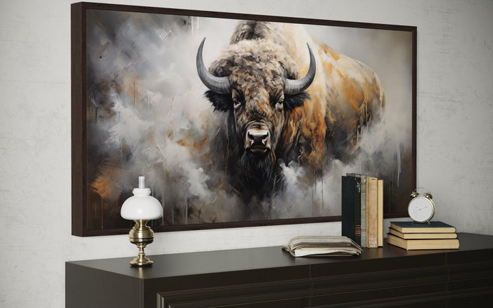 Framed canvas wall art of an American bison in an abstract dripping paint style above a dresser.