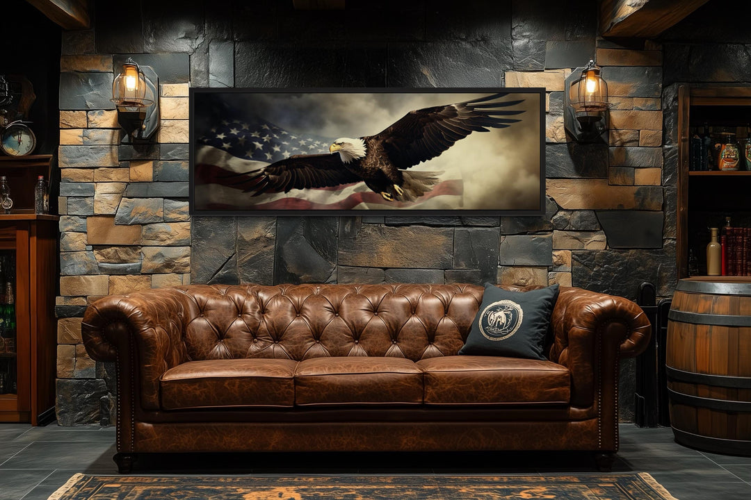 American eagle flying over a USA flag wall art displayed above a brown leather sofa.