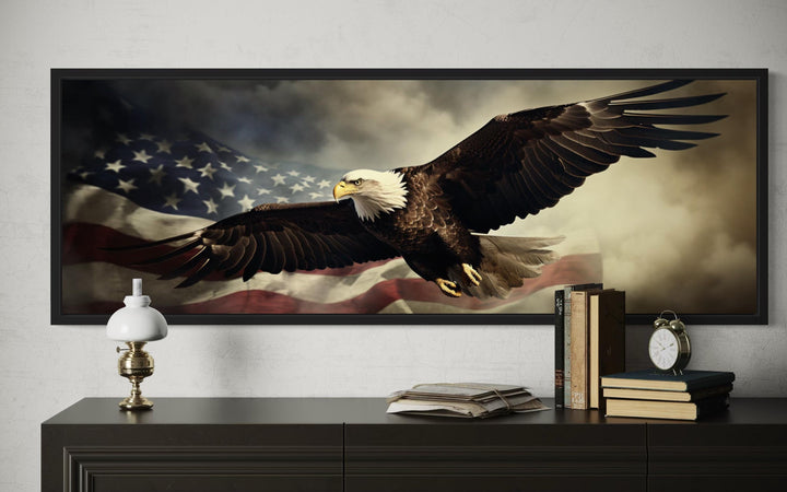 American eagle flying over a USA flag wall art in a black frame above a dark wood dresser.