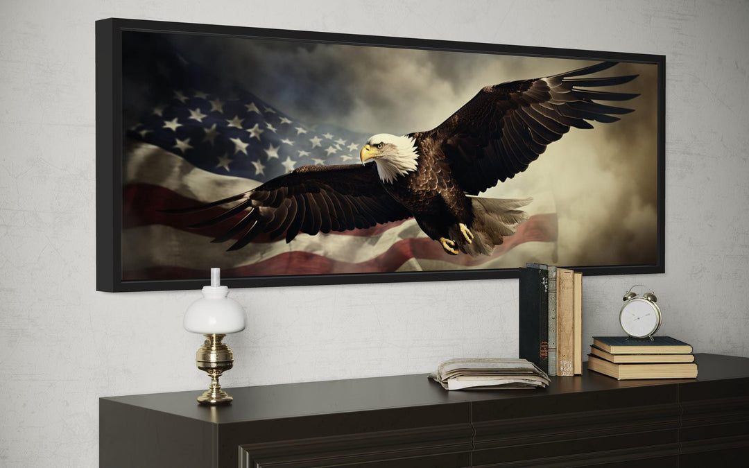American eagle flying over a waving USA flag wall art in a black frame above a dark wood dresser.