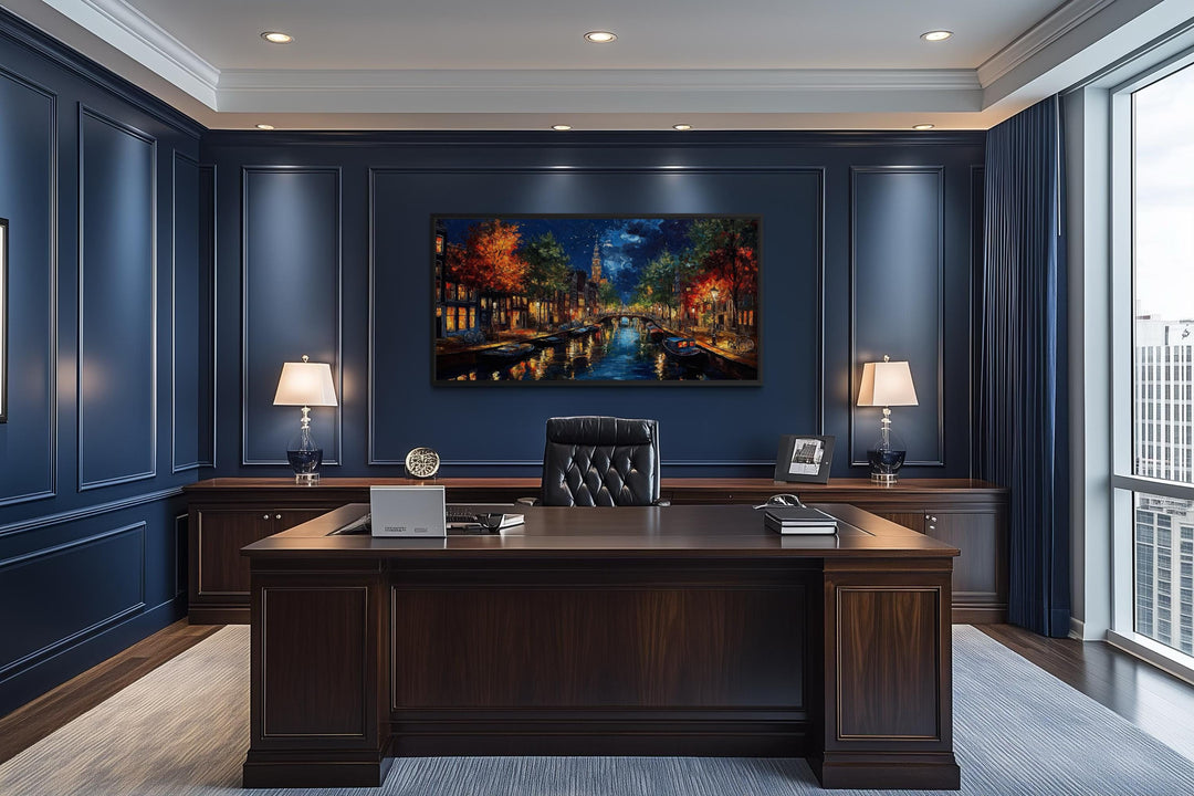 Large horizontal canvas wall art of an Amsterdam canal at night in a dark blue office.