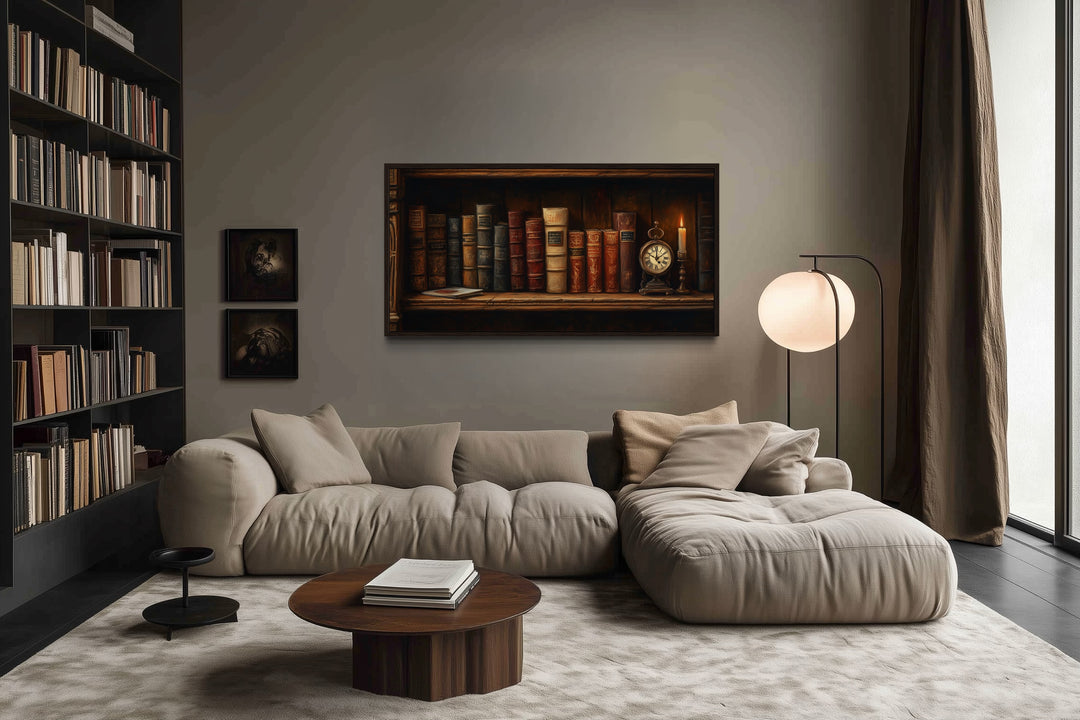 Antique bookcase wall art featuring vintage books, a clock, and a candle above a modern sofa.