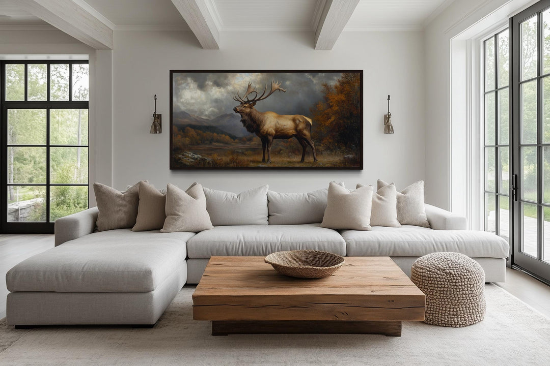 Antique elk in autumn mountains framed canvas wall art hanging above a modern sectional sofa.