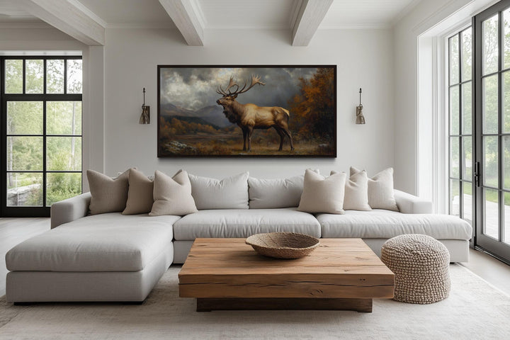 Antique elk in autumn mountains framed canvas wall art hanging above a modern sectional sofa.