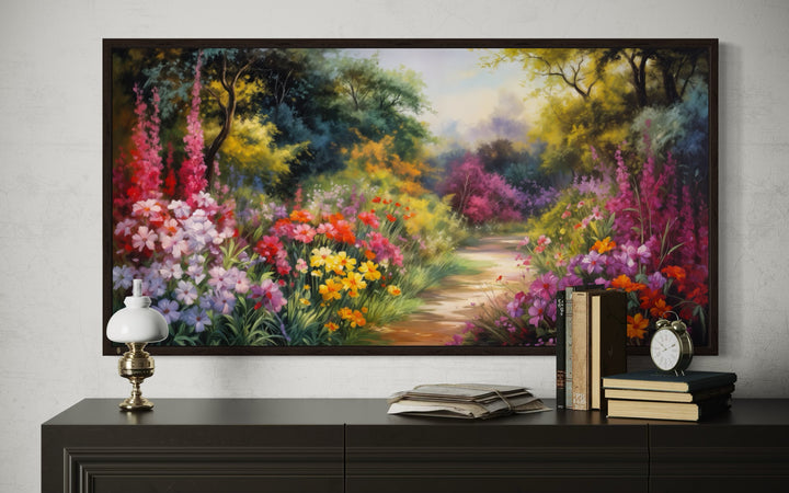 Antique flower garden framed canvas wall art above a dark console with vintage books and a lamp.