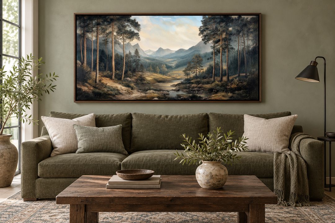 Antique style mountain forest landscape canvas wall art hanging above a green sofa.