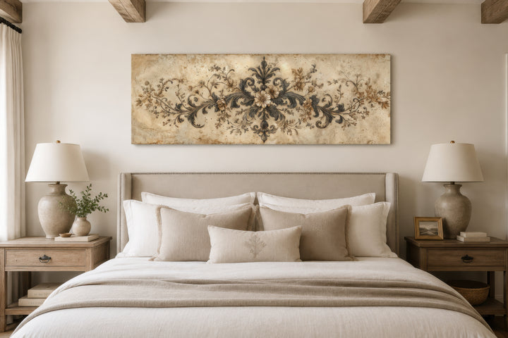 Antique long narrow damask canvas wall art with neutral scrollwork hanging above a bed.