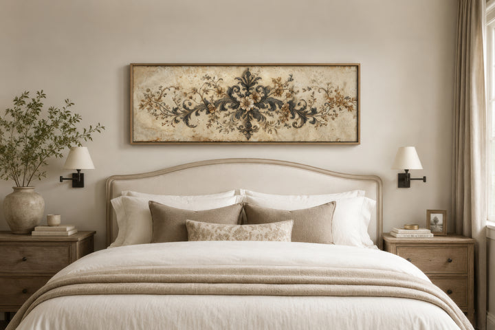 Antique long narrow damask canvas wall art with a neutral floral design hanging above a bed.