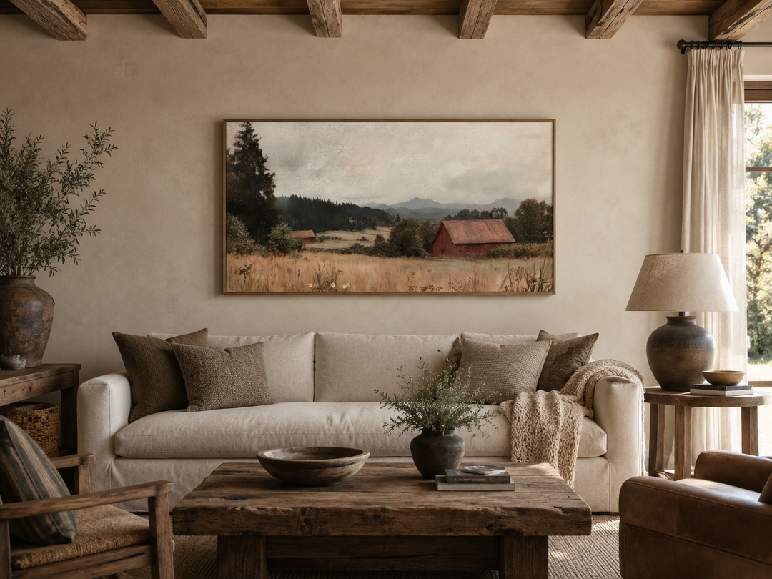 Framed antique red barn canvas print hanging above a neutral sofa in a rustic living room.