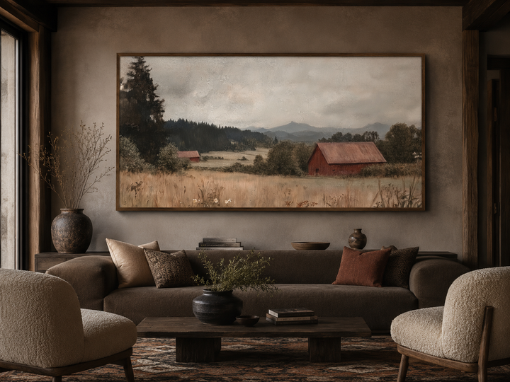 Framed antique red barn canvas print in a rustic living room above a brown sofa.