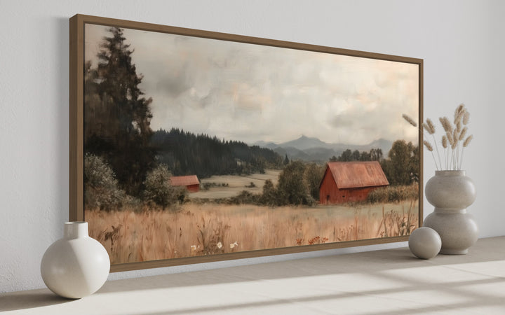 Framed antique red barn canvas print in a rustic farmhouse style, displayed on a neutral shelf.