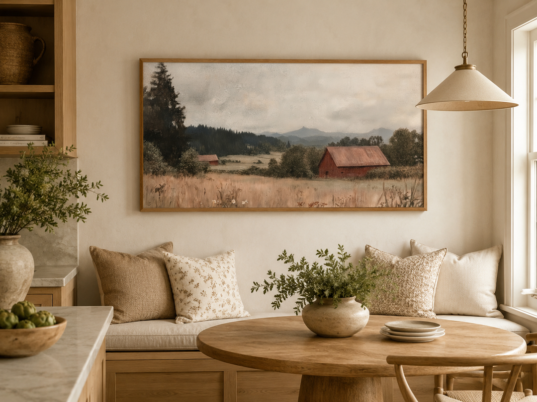 Antique red barn canvas print in a wooden frame hanging above a rustic dining nook.