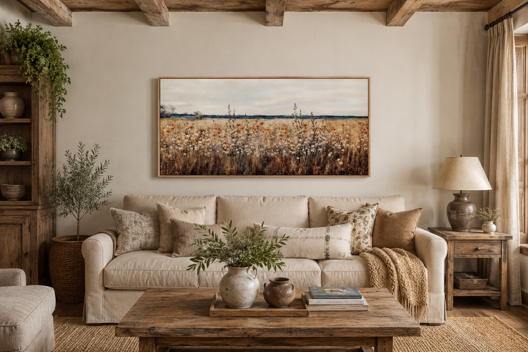 Antique rustic wildflowers field framed canvas wall art hanging above a beige sofa in a cozy room.