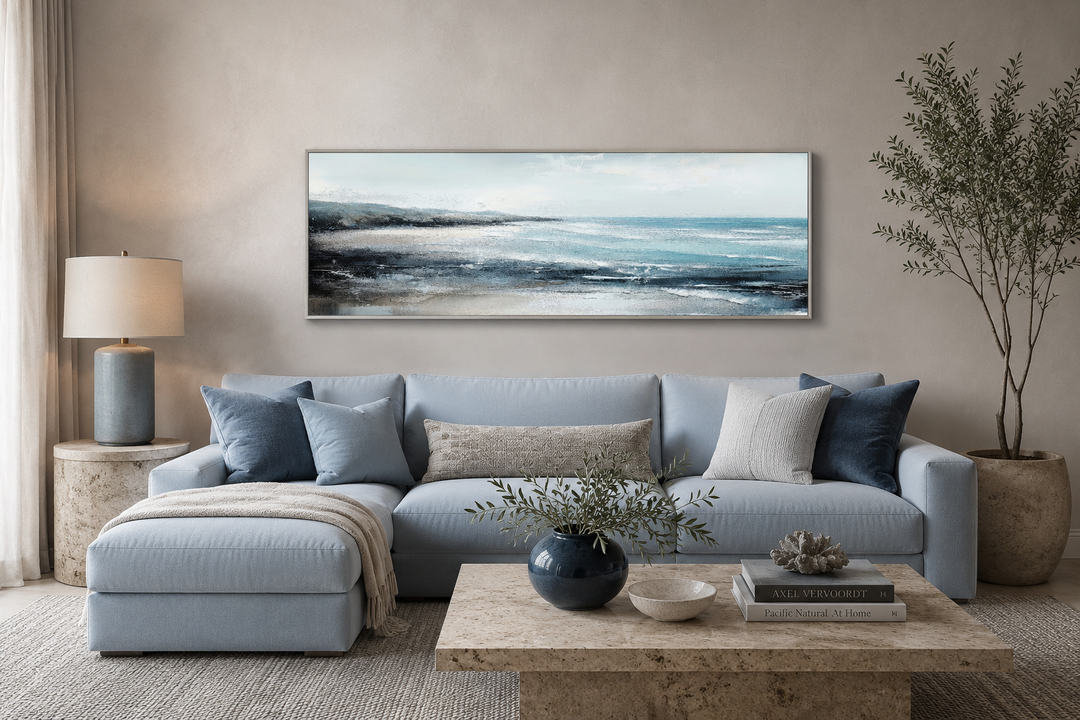 Panoramic aqua blue ocean beach framed canvas wall art hanging above a light blue sectional sofa.