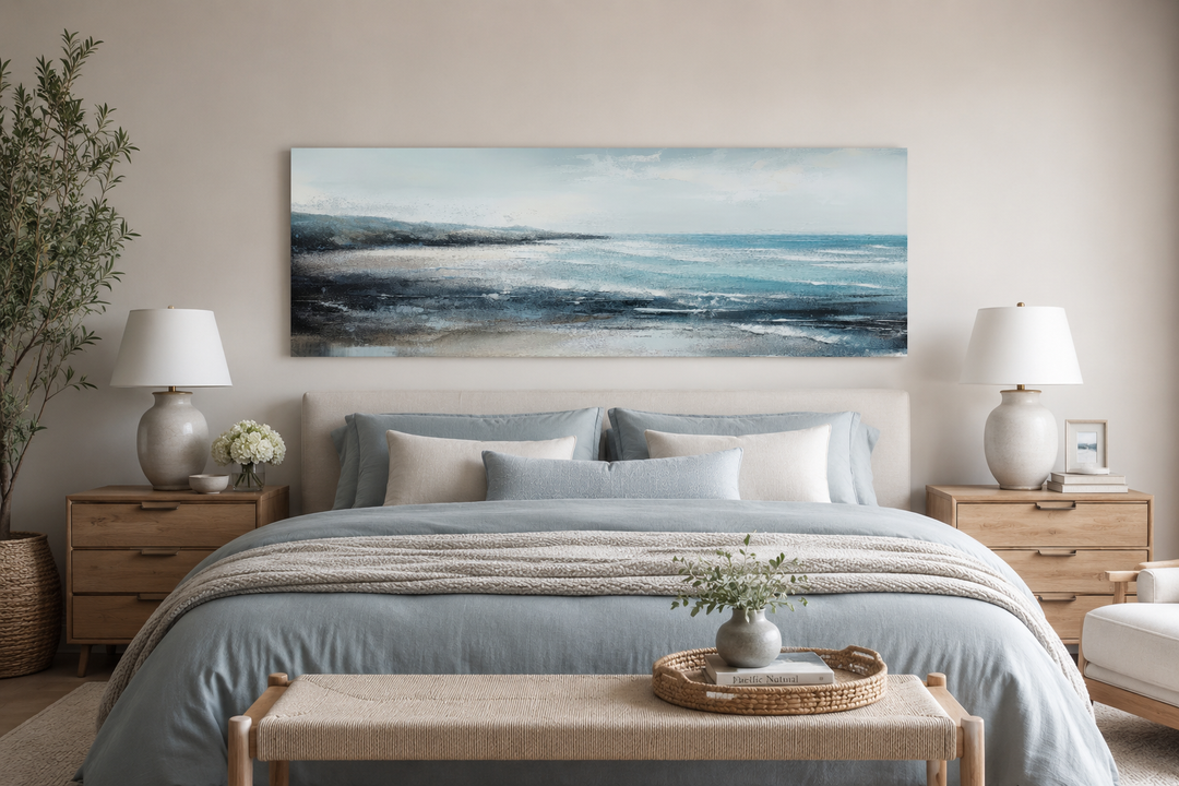 Panoramic aqua blue ocean beach canvas wall art hanging over a bed in a coastal bedroom.