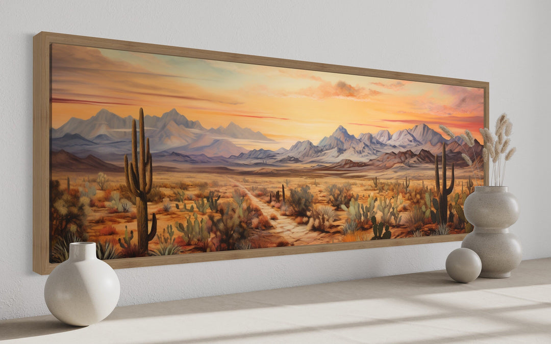 Long horizontal framed canvas art of an Arizona desert landscape at sunset with cacti and mountains.
