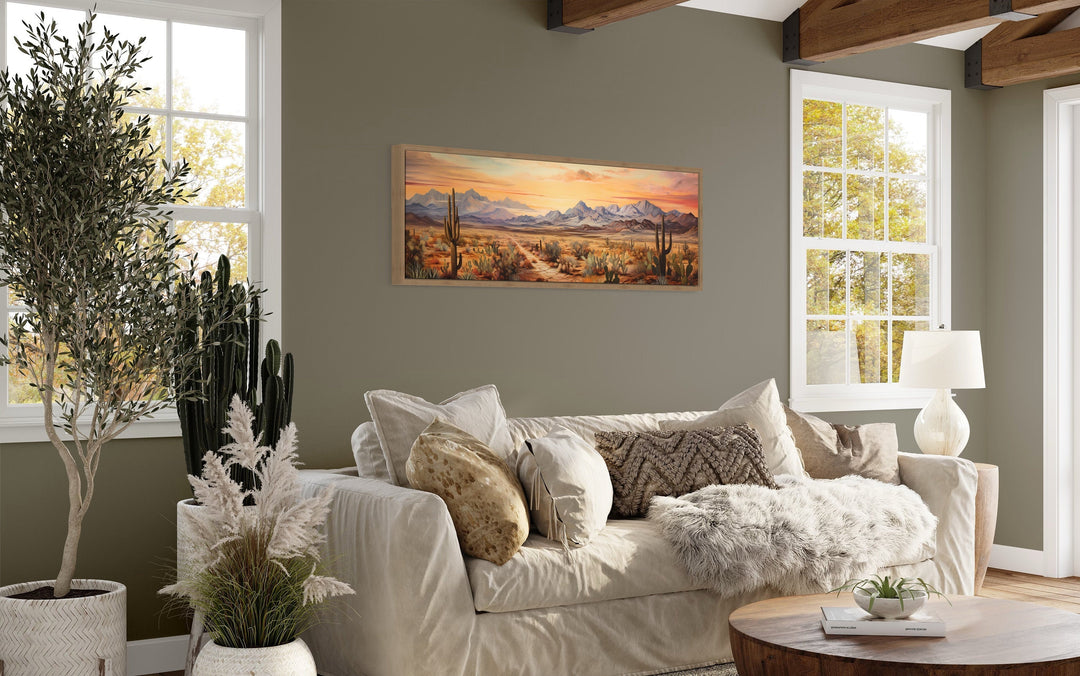 Arizona desert landscape at sunset long horizontal framed canvas wall art above a beige sofa.