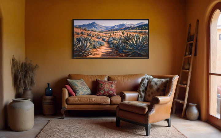 Arizona desert landscape with agave plants framed canvas wall art hanging above a leather sofa.