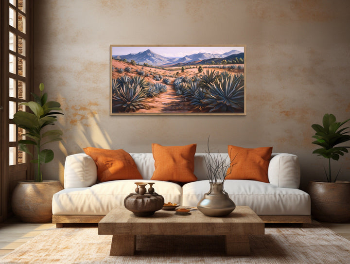 Arizona desert landscape framed canvas wall art featuring agave plants and mountains over a sofa.