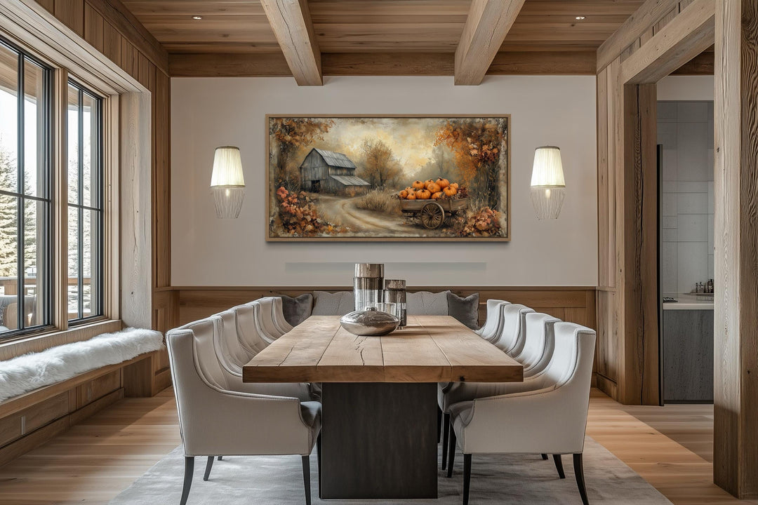 Autumn barn and pumpkin cart farmhouse canvas wall art above a dining table in a rustic room.