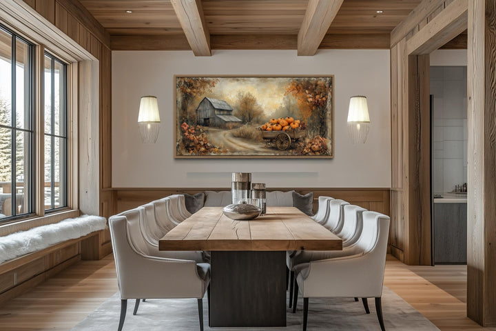 Autumn barn and pumpkin cart farmhouse canvas wall art above a dining table in a rustic room.