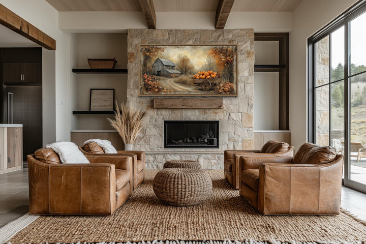 Autumn Barn and Pumpkin Cart Farmhouse Canvas Wall Art displayed above a stone fireplace.