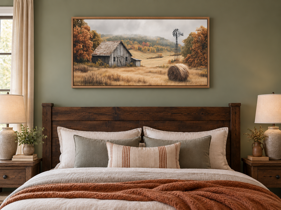 Rustic barn, hay bale, and windmill in a fall landscape canvas wall art above a wooden bed frame.