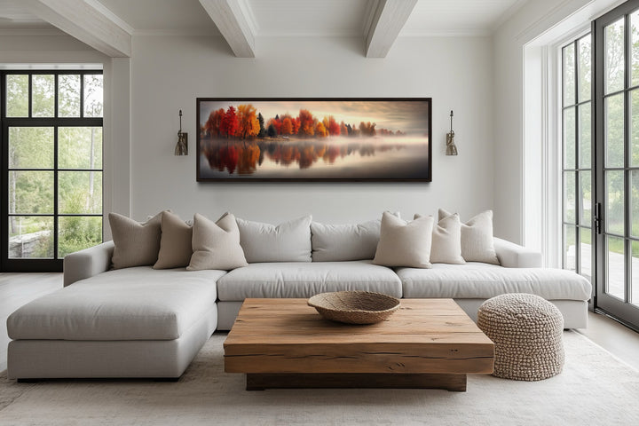 Autumn Forest Lake Reflection Long Horizontal Canvas Wall Art hanging above a modern sofa.